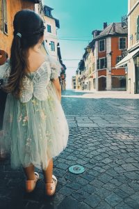 Petite fille marchant dans une rue ensoleillée, photo storytelling lifestyle